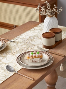 Detail of embroidered leaf texture on premium table runner with decorative tassels