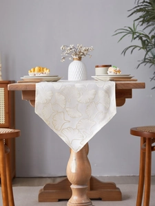 Detailed cream table runner with ginkgo leaf patterns and elegant tassel pendant