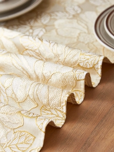 Close-up of luxury jacquard table runner featuring floral patterns and gold silk edges