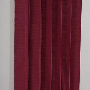 Détail d'un rideau en dentelle bordeaux avec des textures fines tissées horizontales