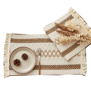 Bohemian woven table runner with geometric patterns and handmade tassels on white background