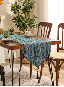 Detailed blue and green striped table runner with elegant fringe tassels for dining decor