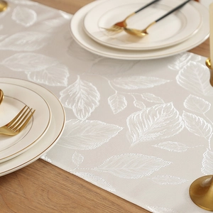 Chemin de table crème luxueux avec motifs de feuilles élégants sur surface bois
