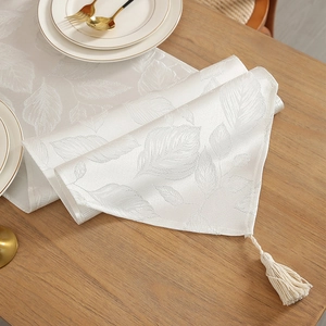 Chemin de table blanc à motif de feuilles et glands sur table à manger en bois