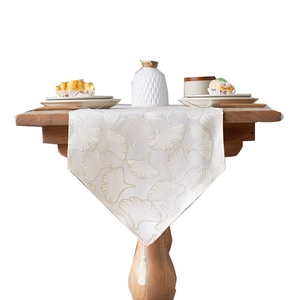 Ginkgo leaf embroidered table runner with tassels on a wooden dining table setup