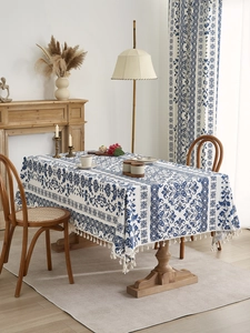 Close-up of blue and white baroque patterns and fringe tassels on a cotton linen tablecloth