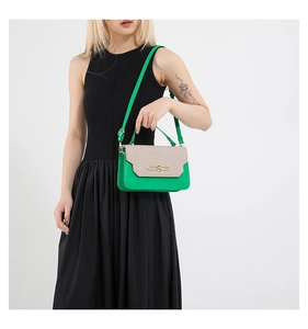 Detail of green leather and beige fabric patchwork handbag with golden metal buckle