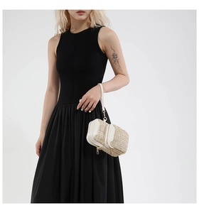 Detail of straw woven bag featuring white leather trim and elegant gold zipper hardware