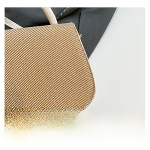 Detail of woven fabric texture and premium leather handle stitching on a crossbody bag