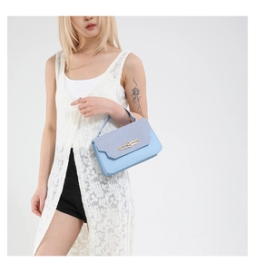 Detail view of a light blue PU leather handbag showing contrasting textures and gold metal clasp