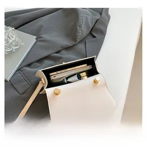 Detail view of the white crossbody bag interior showing phone and makeup storage