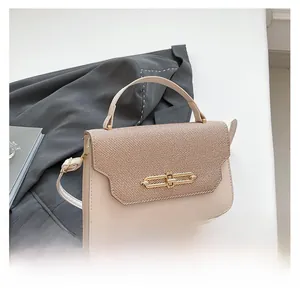 Detail of trendy color-block handbag with striped fabric flap and gold chain lock
