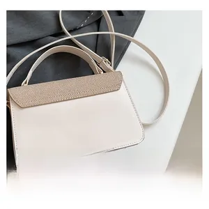Detail view of cream white PU handbag featuring textured woven flap and gold hardware