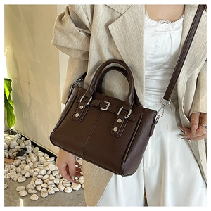 Detailed view of dark brown pebbled faux leather tote with silver metal hardware accents