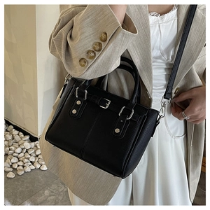 Close-up of black litchi grain leather texture and silver buckle details on tote bag