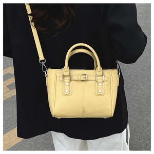 Back view of model wearing a yellow pebble leather tote bag with silver studs