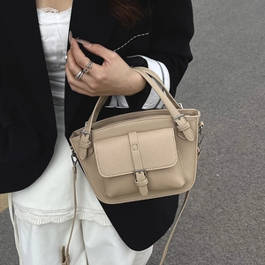 Beige bucket bag in litchi grain leather with top handle and silver buckle detail