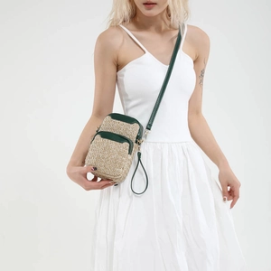 Straw weave mini crossbody bag for women with green trim and adjustable shoulder strap