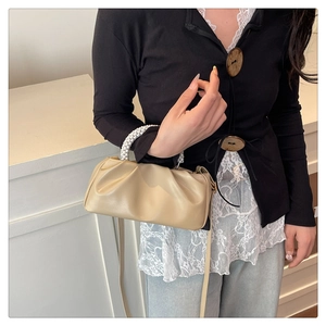 Detail of beige ruched cloud bag with premium pearl handle and slim crossbody strap