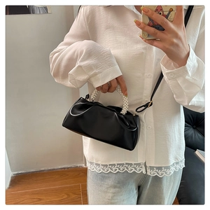 Gros plan du sac nuage noir plissé avec une élégante poignée en perles pour femme