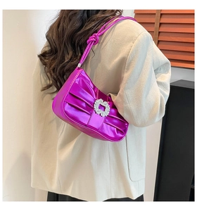 Close-up of metallic purple pleated shoulder bag with sparkling rhinestone buckle
