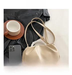 Detail of beige cloud bag featuring ruched PU leather and elegant pearl handle strap