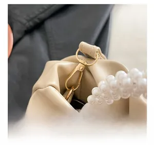 Detailed close-up of premium gold-toned metal clasp and elegant triple-row pearl strap