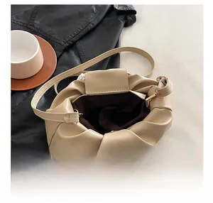 Detail view of the open cloud bag showing spacious interior and deep brown fabric lining
