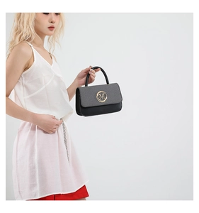 Détail du sac à main bicolore avec boucle dorée 'M' et poignée supérieure