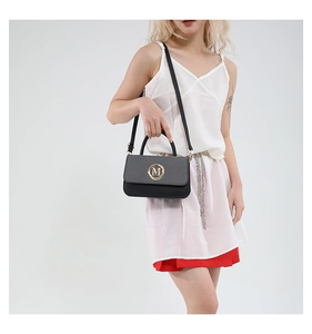 Mannequin portant un sac à main boîte noir avec boucle M dorée et finitions en cuir mixte