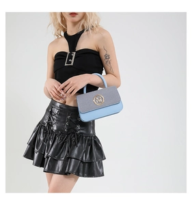 Détail du sac à main gris et bleu clair avec logo M doré et finition cuir texturé