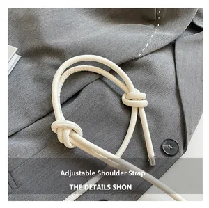Detail of adjustable knotted cream leather shoulder strap with silver metal hardware