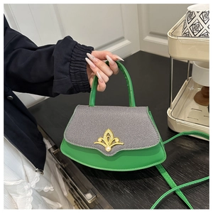 Detail der grünen Handtasche mit Kronenverschluss, Perlen und grauer Textilklappe