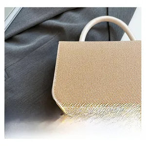 Gros plan sur la texture de paille tissée et l'anse en cuir blanc d'un sac à main chic