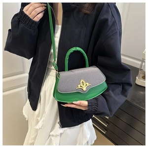 Details der grünen Lederhandtasche mit grauem Stoff und goldenem Kronenverschluss und Riemen