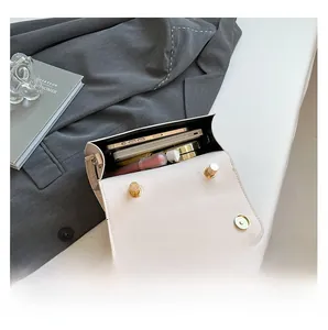 Vue intérieure de la petite sacoche en cuir PU crème avec téléphone et maquillage