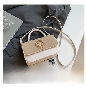 Détail du sac crème avec rabat à texture tissée et boucle dorée avec logo M en relief