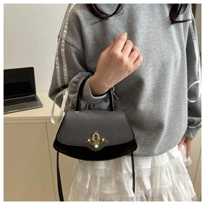 Detailansicht der fächerförmigen Handtasche mit Kontraststoff und goldenem Lotusschluss