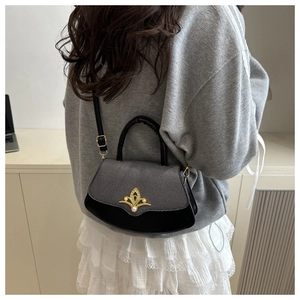Detail der eleganten fächerförmigen Tasche mit Goldkrone-Verschluss und Perle am Schultergurt