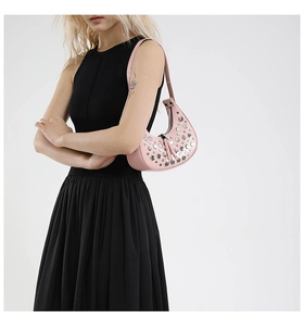 Detail view of pink hobo bag with silver rivets and metal zipper on shoulder strap