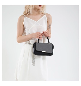Dettaglio di una borsa chic in patchwork nero e grigio con fibbia dorata quadrata