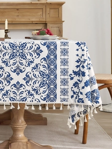 Detail of blue and white floral tablecloth with elegant beige fringe trim
