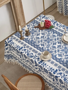 Detail of blue and white baroque tablecloth with elegant tassel trim and cotton fabric