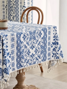 Close-up of blue and white Chinese style tablecloth with delicate white fringe detail