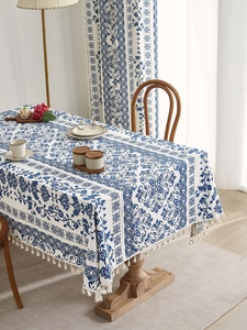 Close-up of rectangular blue floral tablecloth with cotton linen texture and white tassels