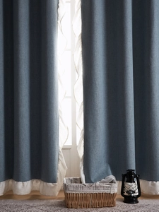 Détail de rideau en lin bleu marine avec bordure à volants crème et drapé sophistiqué