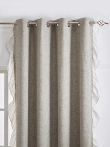Close-up of gray linen curtain with white ruffled edge and silver metal grommets