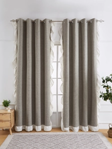 Detail of grey linen curtains with white ruffle edges and silver metal grommets