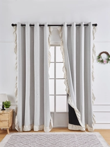 Detail of light gray linen blackout curtain with beige ruffle edges and grommet top