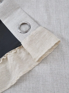 Detail of oatmeal linen blackout curtain showing silver metal grommet and thick texture